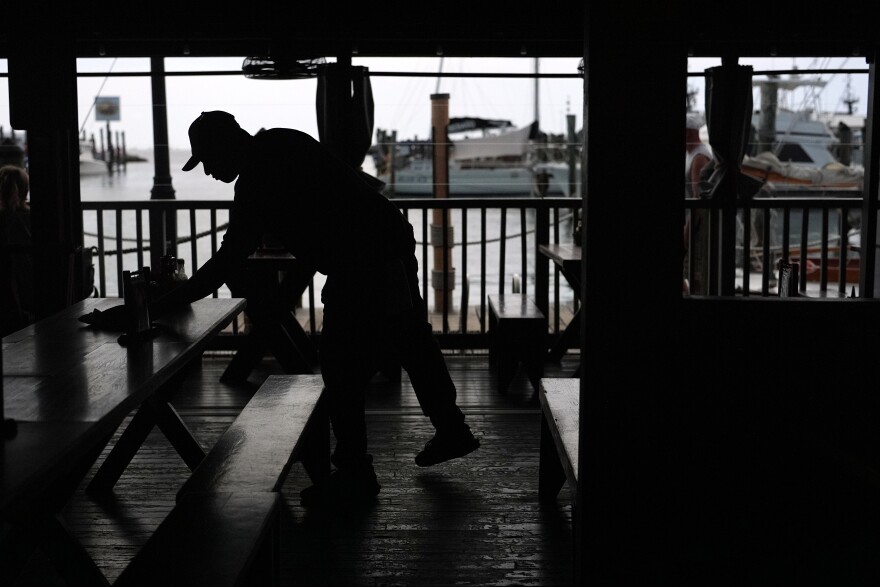 A Haitian worker with Temporary Protected Status cleans and busses tables at Half Shell Raw Bar, Friday, July 24, 2026, in Key West, Fla.