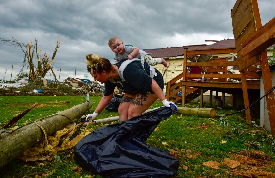 Kaitlyn Robinson came to help pick up storm debris with her daughter, Olivia, strapped to her back on Monday, May 19, 2025.
