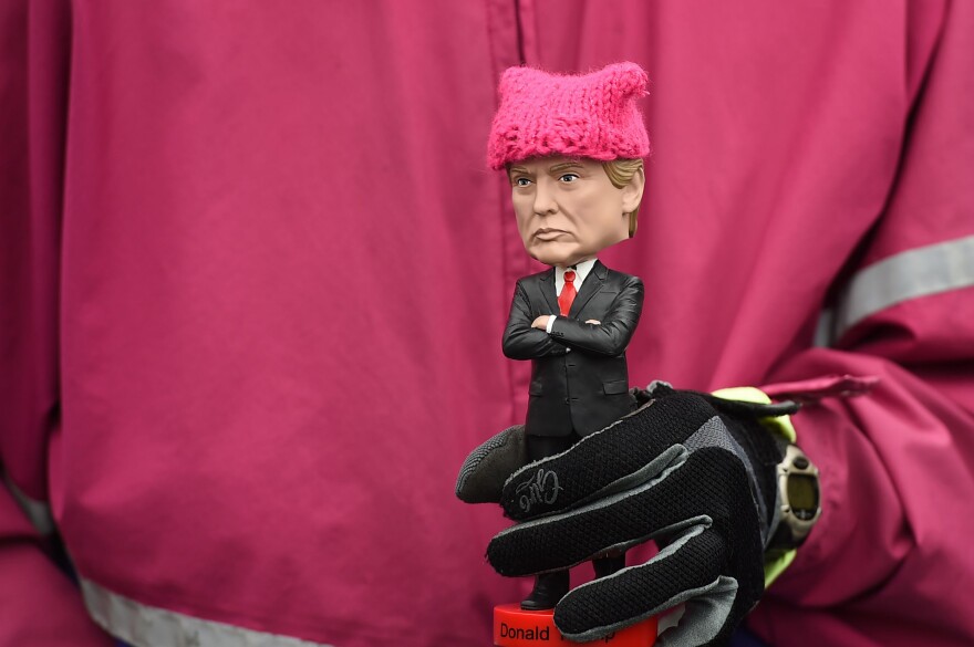 A protester holds a Donald Trump bobble-head donned with a tiny pink "pussy hat" during Saturday's march in D.C.