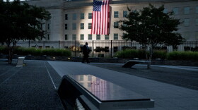 As seen from the Pentagon Memorial, a U.S. flag is draped on the side of the Pentagon where the building was attacked on Sept. 11 in 2001, on the 14th anniversary of the attack, Friday Sept. 11, 2015, in Washington. (Jacquelyn Martin/AP)