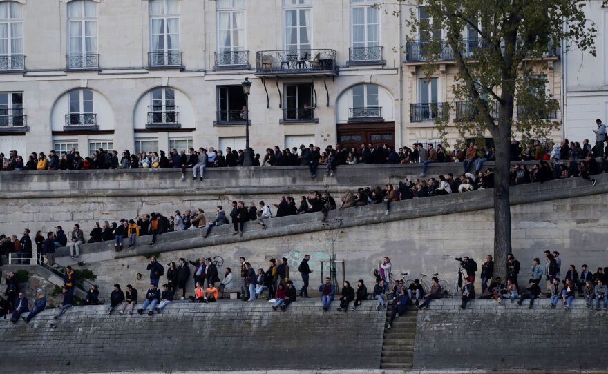 Thousands watched in horror as Notre Dame burned on Monday, some capturing the moment on their cell phones or singing hymns.