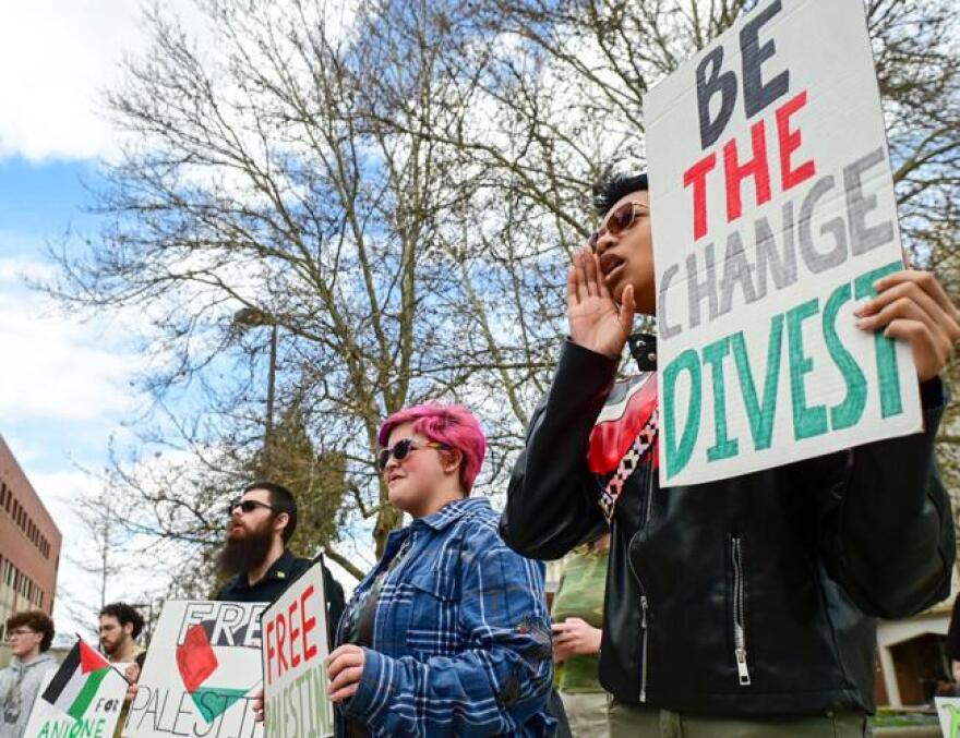 Protestors gathered at the University of Idaho library in Moscow hold posters and listen to speakers, including UI freshman Basil Hennes, center, and Autumn Austin. (Liesbeth Powers/Moscow-Pullman Daily News)