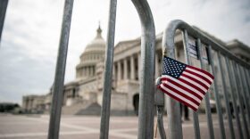 An American flag is placed on a fence outside of the U.S. Capitol building in Washington, DC.