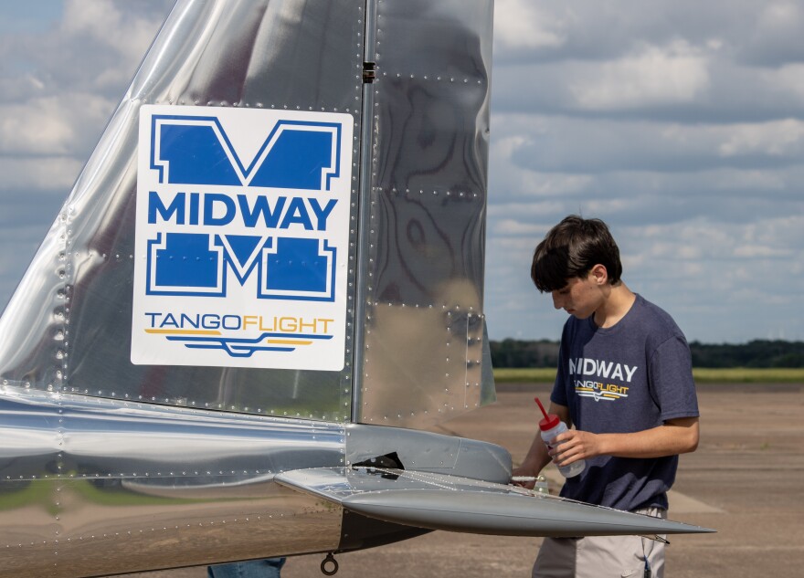A Midway High School Tango Flight capstone student cleans the completed airplane before a celebration ceremony and public viewing on Wednesday, May 20. The students built the plane over the course of two years.