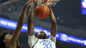 Kentucky's Ugonna Onyenso (33) dunks while defended by Mississippi's Jaemyn Brakefield, left, during the first half of an NCAA college basketball game Tuesday, Feb. 13, 2024, in Lexington, Ky. (AP Photo/James Crisp)