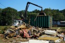 A claw operator scoops up debris from homes demolished following Hurricane Helene in Old Fort, N.C., on Thursday, Sept. 11, 2025.