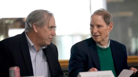U.S. Sens. Jeff Merkley, left, and Ron Wyden confer during a town hall held at the Federal Building in Portland, Ore., March 17, 2025. The event aimed to provide an opportunity for federal employees to talk about the impact of layoffs in the federal government.