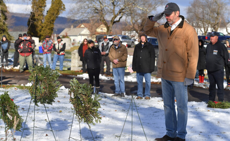 Tony Brooks salutes after placing a wreath for the Merchant Marines.