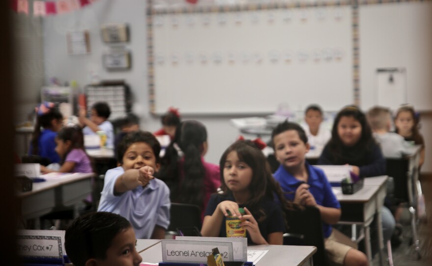 First graders in Mrs. Alvarez's were excited to notice the camera peeking in through their classroom door window.