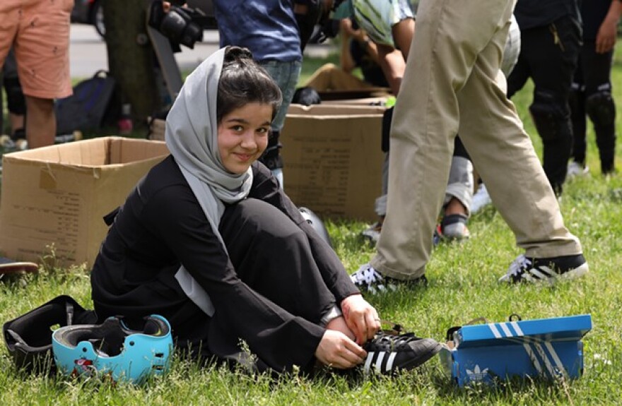 Shamila ties up a pair of skate shoes for Rolling Resettlement's outing to the Roc City Skatepark.