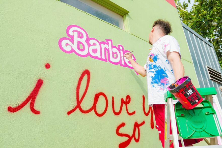 Austin artist Joe Hermosa adds Barbie elements to the popular "I love you so much" mural on South Congress Avenue.