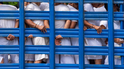 FILE - People detained by national police in the department of La Libertad stand in a truck as they are taken to a detention center in Soyapango, El Salvador, Oct. 7, 2022, during a state of the emergency.