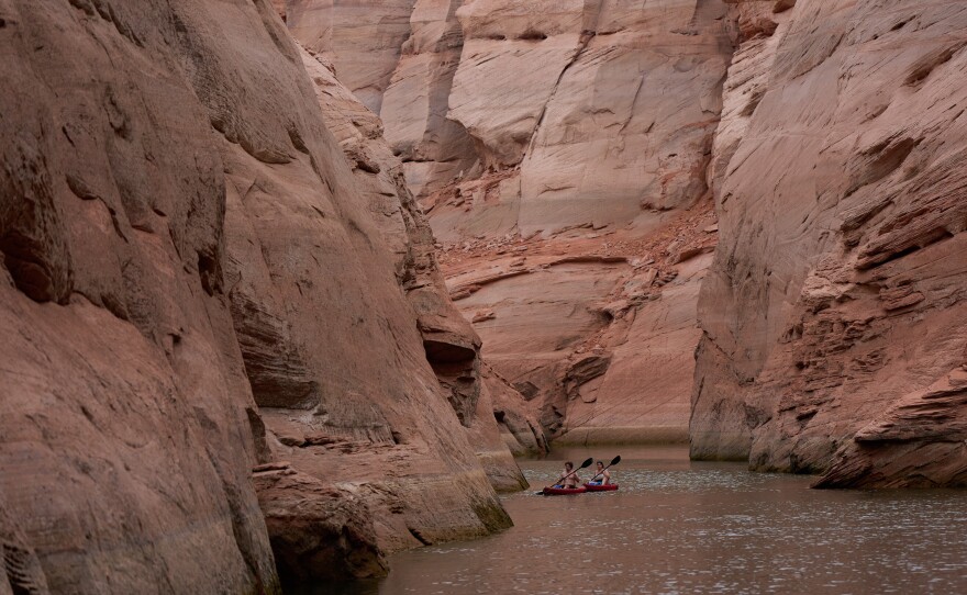 People paddle through a canyon on Lake Powell at the Glen Canyon National Recreation Area, Wednesday, July 15, 2026, near Page, Ariz.