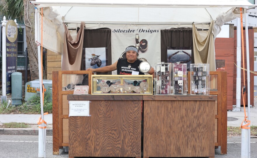 Artist in a booth at the Gainesville Downtown Festival and Art Show.