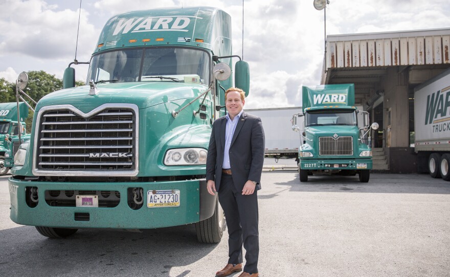 Bill Ward poses for a photo with one of new trucks