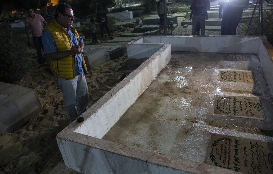 Dr. Izzeldin Abuelaish prays in 2021 at the graves of his three daughters and a niece who were killed by an Israeli tank shell at his home in northern Gaza in the 2009 fighting between Israel and Hamas.