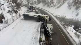 A semi-tractor trailer straddles the barrier between the westbound and eastbound lanes after sliding out of control on westbound Interstate 70 in Glenwood Canyon Monday morning.