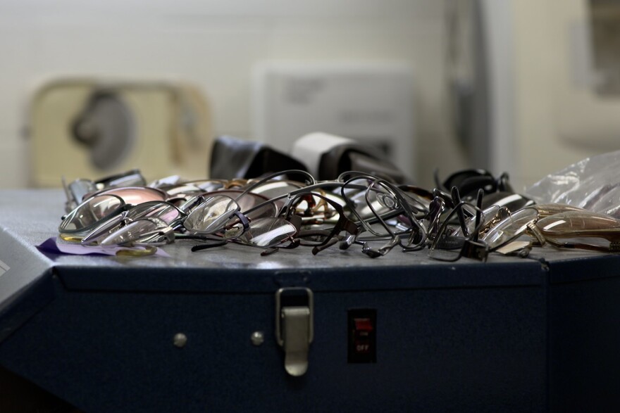 Pairs of glasses sitting on a table. 
