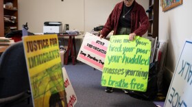Sister Anne McCarthy with the Benedictine Sisters of Erie looks through her signs protesting President Donald Trump’s nationwide immigration crackdown.