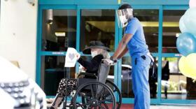 Margaret Choinacki, center, 87, waves goodbye after a drive-by visit by her friend Frances Reaves at Miami Jewish Health in Miami in Miami, FL.