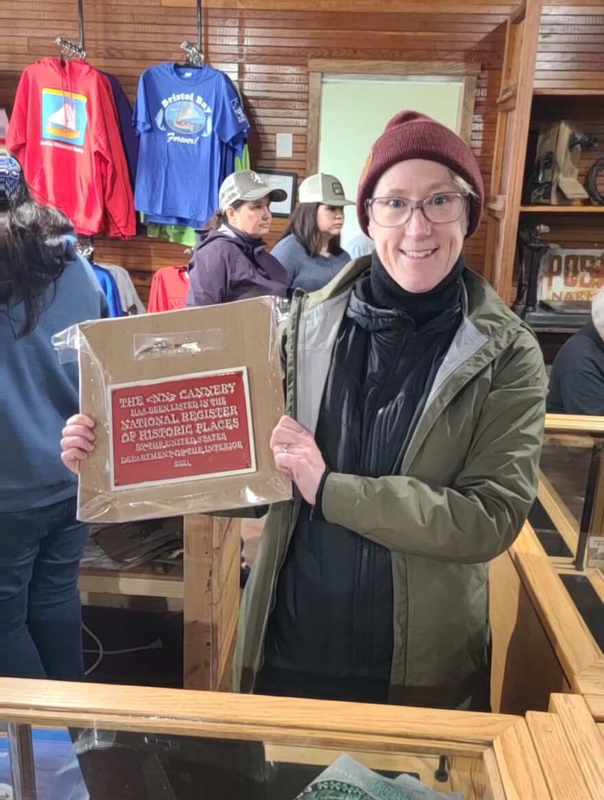 Katie Ringsmuth holds a plaque that is now mounted on the Diamond NN Cannery marking its listing on the National Registry of Historic Places