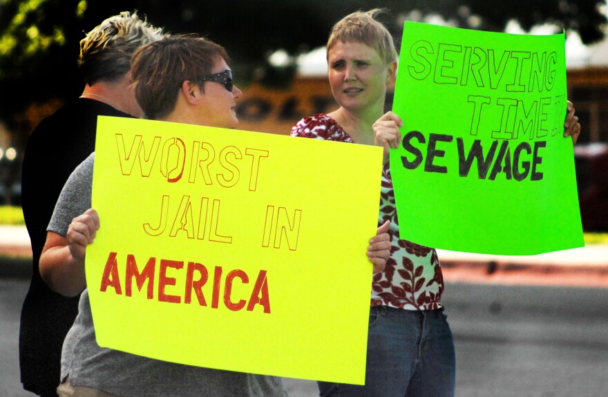 Ginny Sain, left and Anna Marie Lane protest the conditions at the Oklahoma County Jail Tuesday evening.
