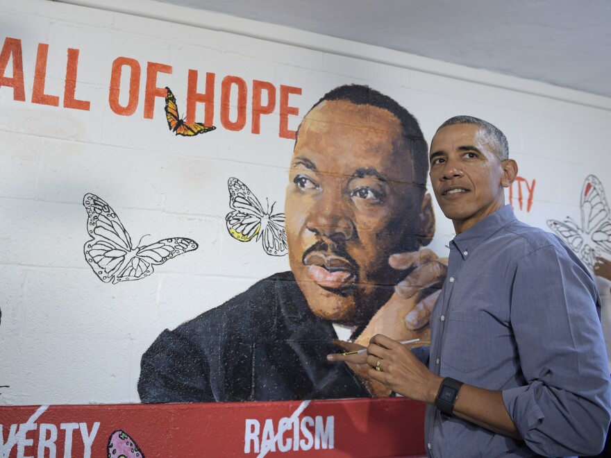 Then-President Barack Obama helps paint a mural of Martin Luther King Jr. in 2017.