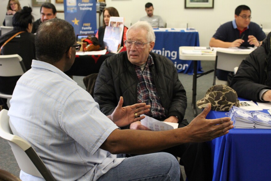 A Wal-Mart employee talks to a Juneau Job Center staffer during a Jan. 29 job fair. (Photo by Elizabeth Jenkins/KTOO)