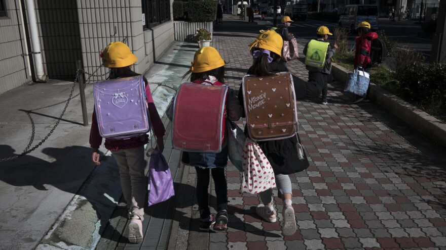 Japan is asking all schools from the elementary to high school level to shut down for the next month, citing the risk of spreading the COVID-19 coronavirus. Here, elementary school students head home Thursday in Ichikawa, Japan.