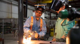 Simon Denby, a 49 year old apprentice instructor, helps a student at Ironworkers local 29 steel work in Dayton, Ohio, on October 24, 2022. - In the face of the rising prices that are crushing this election campaign, Joe Biden is hammering home his message: the tens of billions of dollars voted on by the Democrats will revive American manufacturing and its "good-paying jobs." He is trying to reconnect with the white working class, which has been largely lost to a Democratic Party that has long supported free trade. But in Ohio, where Donald Trump came out on top in the last two presidential elections, inflation and a deep sense of disenfranchisement are hampering this strategy. (Photo by Megan JELINGER / AFP) (Photo by MEGAN JELINGER/AFP via Getty Images)