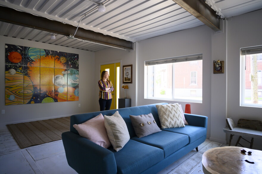 Gina Sheridan stands in the living area of her household's brand-new, shipping-container-built home.