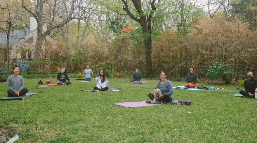 Eight women of Asian descent sit criss-cross on top of their yoga mat. They've gathered for a restorative yoga healing session with the group Dallas Women of Asian Descent.