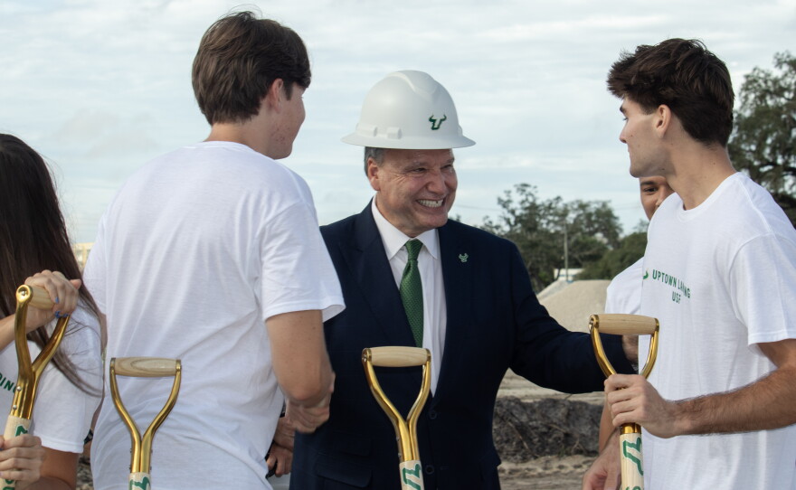 USF President Moez Limayem smiles with students at a groundbreaking ceremony for Uptown Landing. 