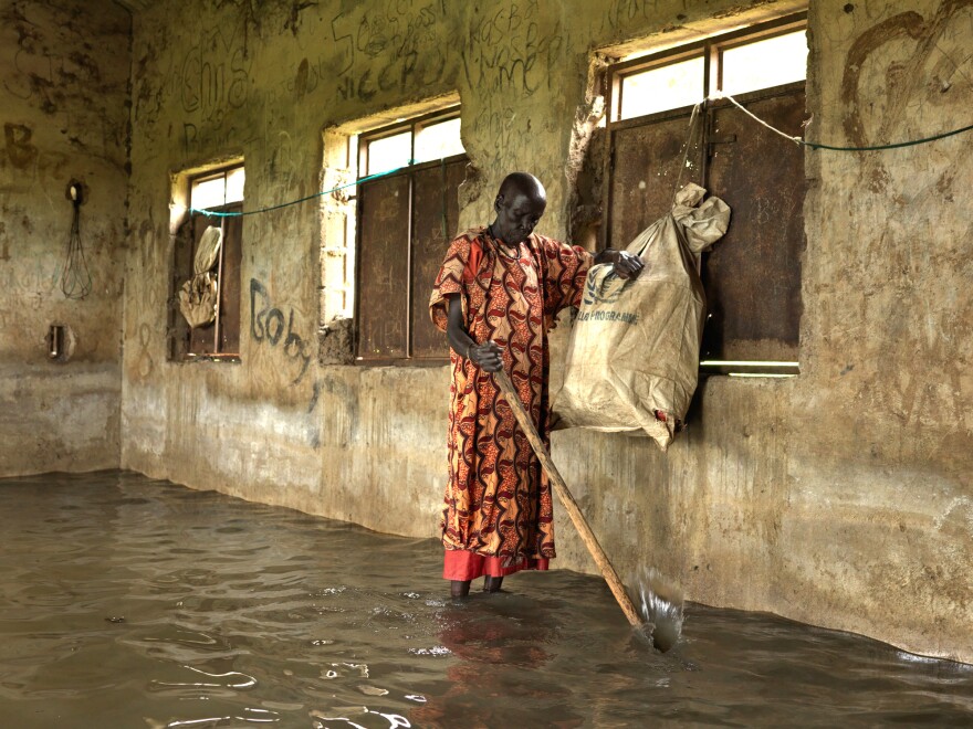 Nyakeak Rambong, 71, stands inside the abandoned school, used as a refuge for villagers displaced by the floods in 2020. "The dike that we built around the school broke in all corners and we couldn't rescue the school anymore," she says. (September 2021)