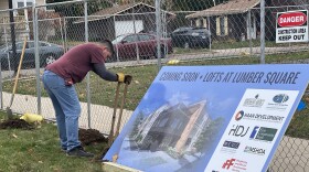 Todd Meyers of Fastsigns of Traverse City puts up a billboard teasing the Lofts at Lumber Square outside the groundbreaking ceremony on the empty lot.