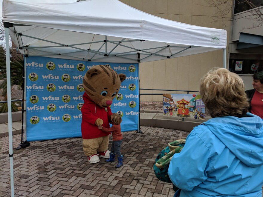 One of the event's small visitors gets neighborly with PBS Kids star Daniel Tiger.