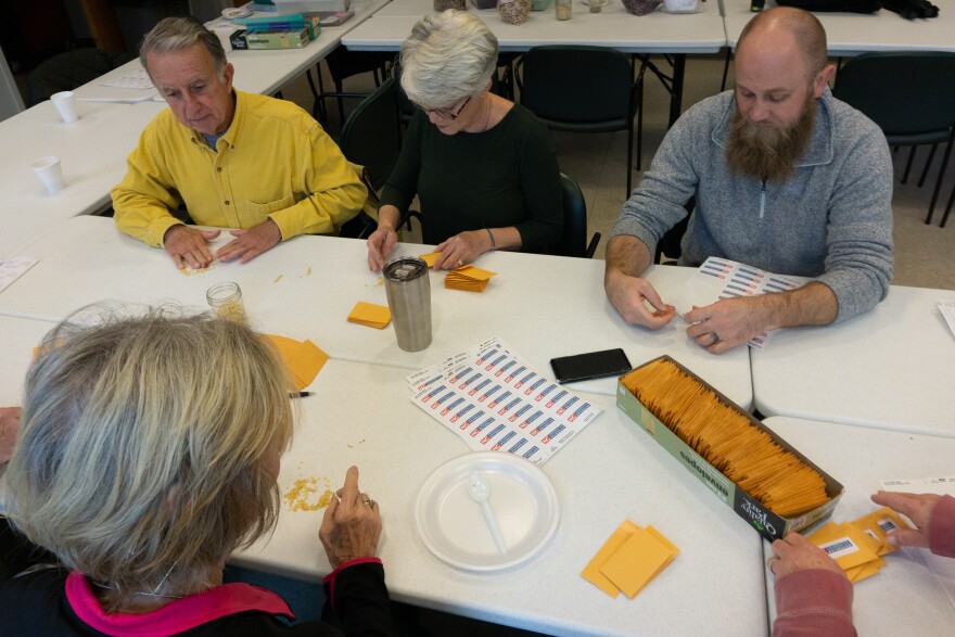 Ashe County Cooperative Extension Master Gardeners pack seeds from the 2019 Victory Garden harvest into small manila envelopes 