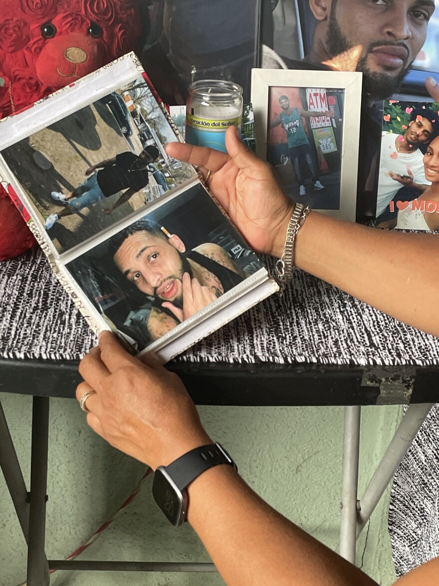  Alrene Garcia holds a photo book of pictures of her son, Kevin Johnson.