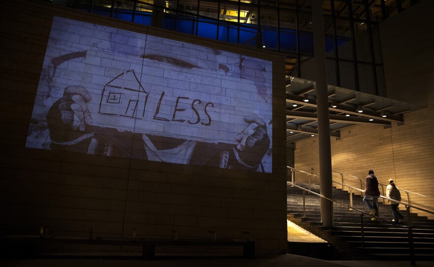 Images are projected onto the side of City Hall on Wednesday, November 1, 2017, during a rally to protest sweeps of encampments in Seattle.