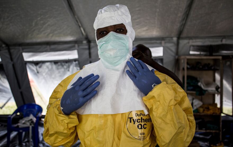 A medical worker puts on protective gear at an Ebola treatment center in Beni in the Democratic Republic of the Congo. Officials want to train workers at all health facilities to take precautions.