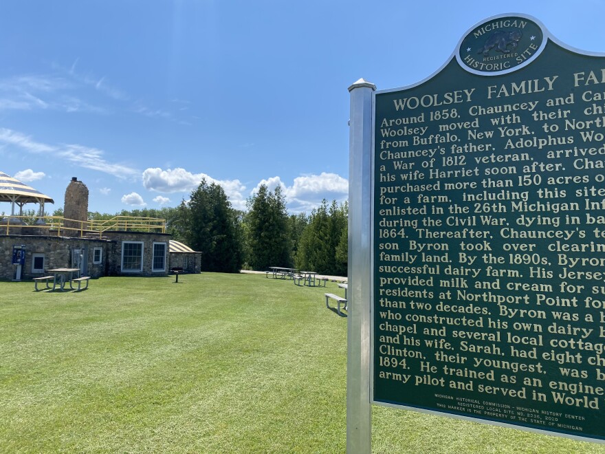 A historical marker telling the story of the Woolsey family is in front of an old stone building that serves as the Woolsey Airport.