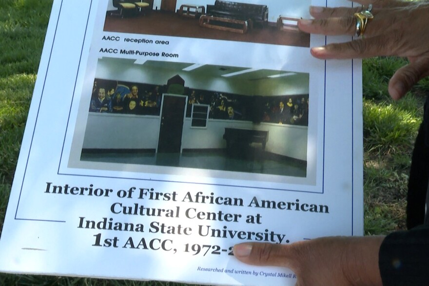 Historian Crystal Reynolds shows a photo of the murals inside of the original African American Cultural Center on 9th Street in Terre Haute. 