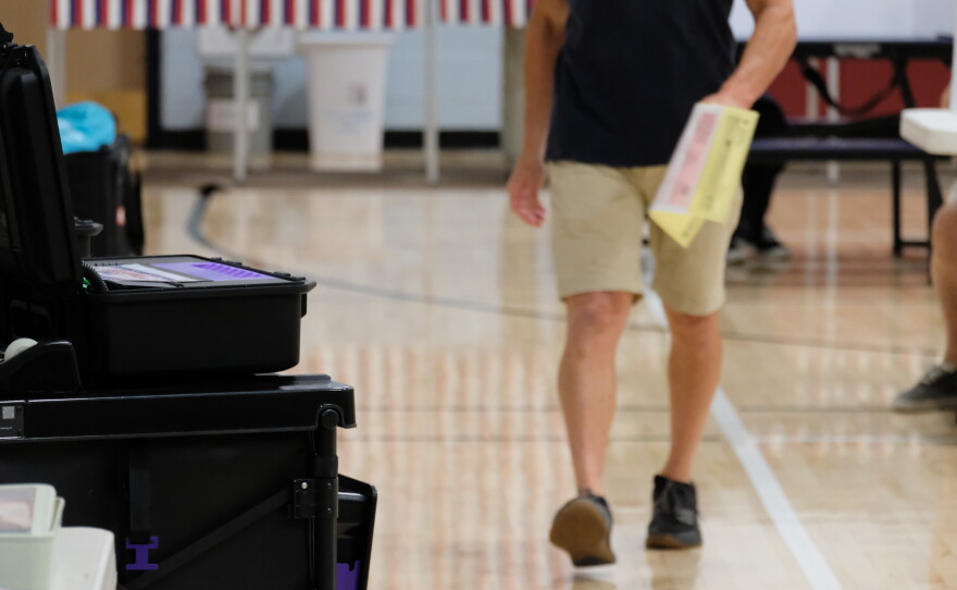 A voter approaches a ballot counting machine in Rye, NH, on Sept. 8, 2026.