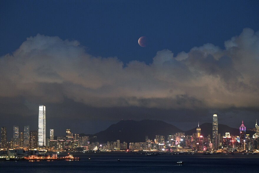 The moon rises over Victoria Harbour in Hong Kong on Wednesday.