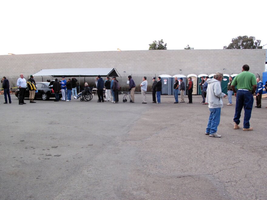 People line up to receive water from Waterman Dave. Aside from water, many come for the chance to joke around with Ross.