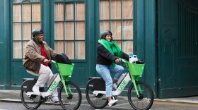 Two people are riding e-bikes.