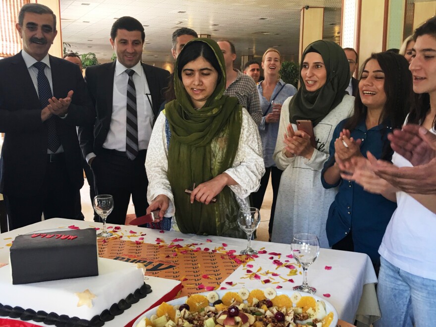 Malala cuts a birthday cake in the shape of a book at a restaurant in Dohuk. The youngest Nobel laureate turned 20 on July 12 in Dohuk, five years after she was shot in the head by a Taliban gunman in Pakistan.
