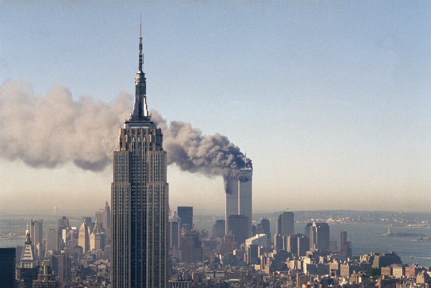 The twin towers of the World Trade Center burn behind the Empire State Building in New York, Sept. 11, 2001. In a horrific sequence of destruction, terrorists crashed two planes into the World Trade Center causing the twin 110-story towers to collapse. (AP Photo/Marty Lederhandler)