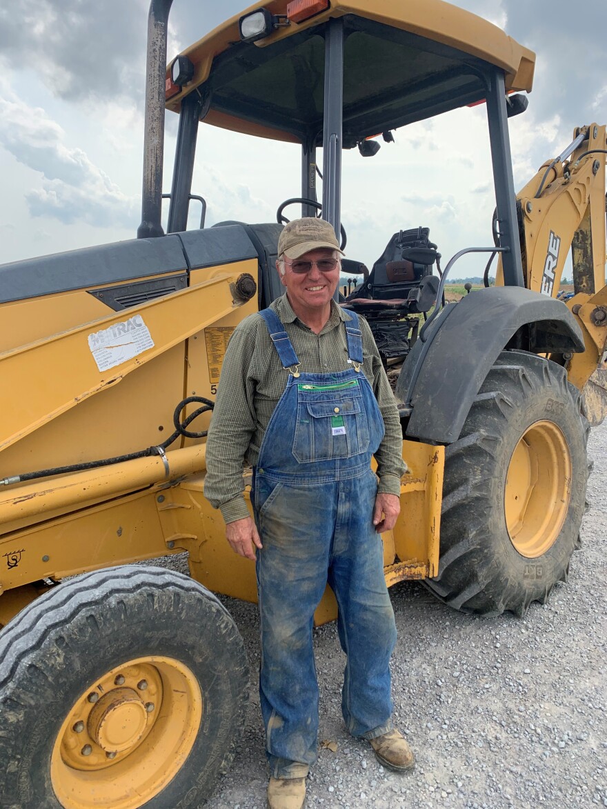 Bremen, Kentucky farmer Tim Hendrix stands next to a 12,000 pound backhoe that was thrown 40 feet with the brakes still on by the Dec. 10-11 tornadoes.