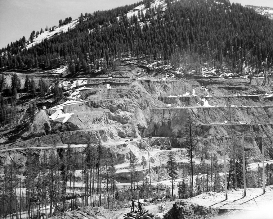 black-and-white photos of the Stibnite Mining district show road and mining scars on the landscape.
